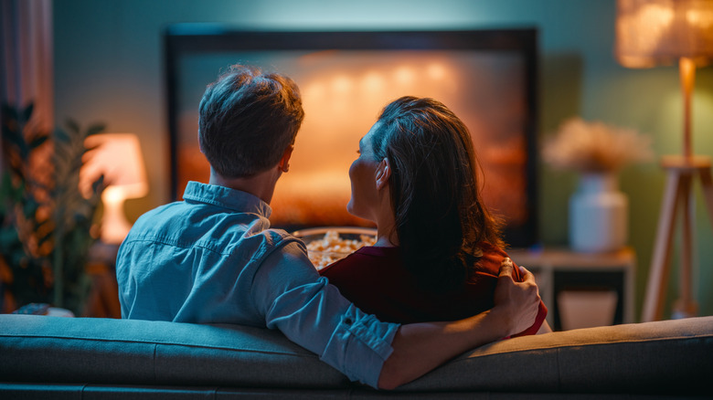 Couple sitting on home cinema couch