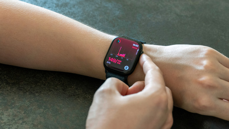 A man's hand touching the Digital Crown on an Apple Watch.