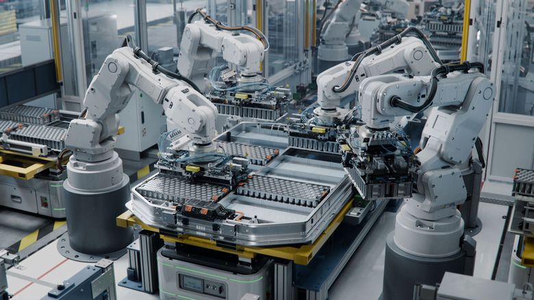 Robotic arms assembling EV batteries