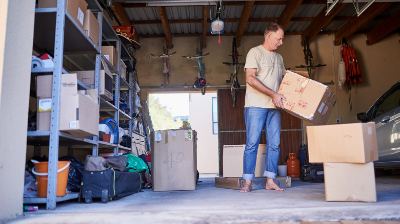 person holding cardboard box in garage