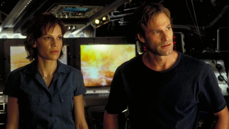 Major Rebecca Childs and Dr. Joshua Keyes standing next to each other and listening