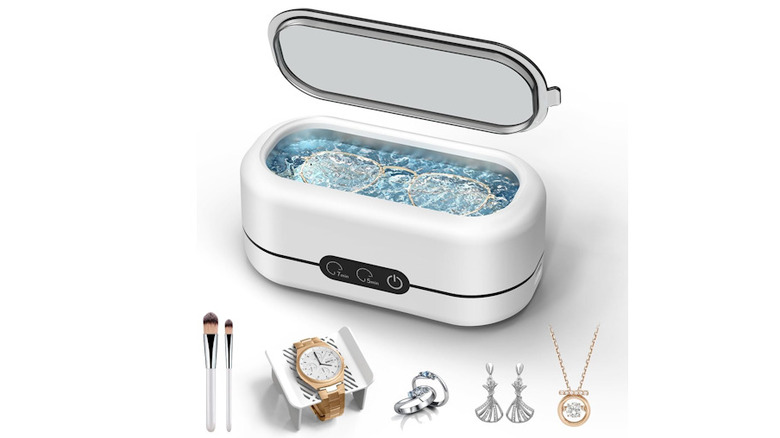 The Ultrasonic Cleaner Machine with several pieces of jewelry surrounding it