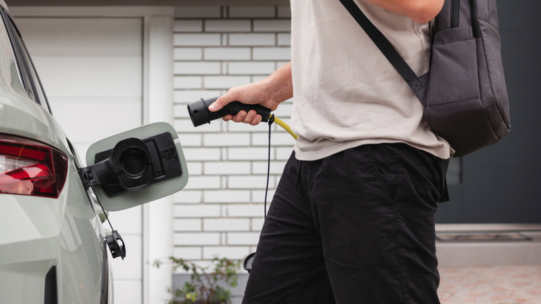 Man plugging in an electric vehicle to be charged