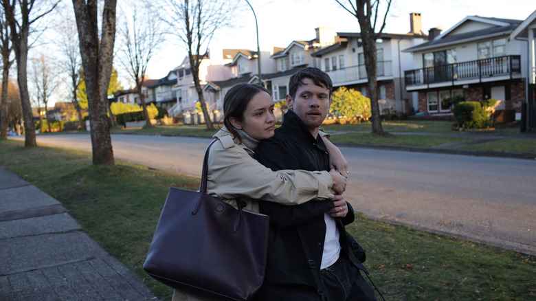 Emma hugging Jude from behind on the street