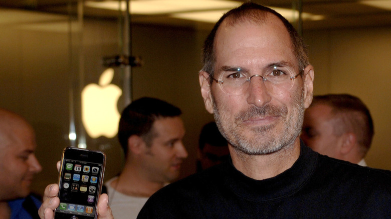 Steve Jobs holding the original iPhone