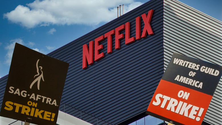 SGA protest signs being held in the foreground with a Netflix office building in the background