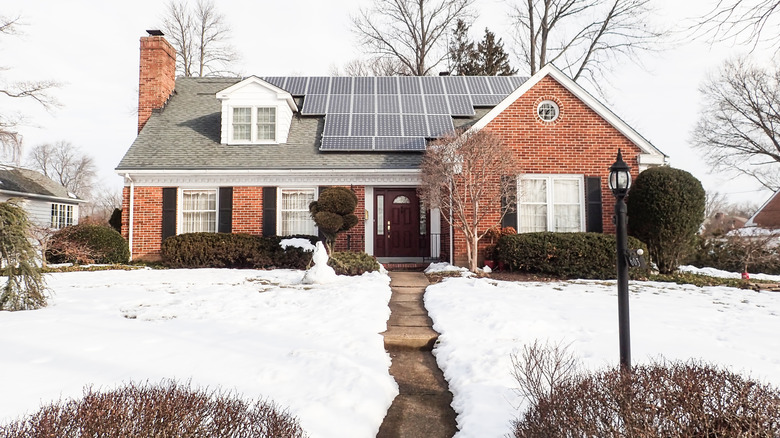 a house in the snow with solar panels on the roof