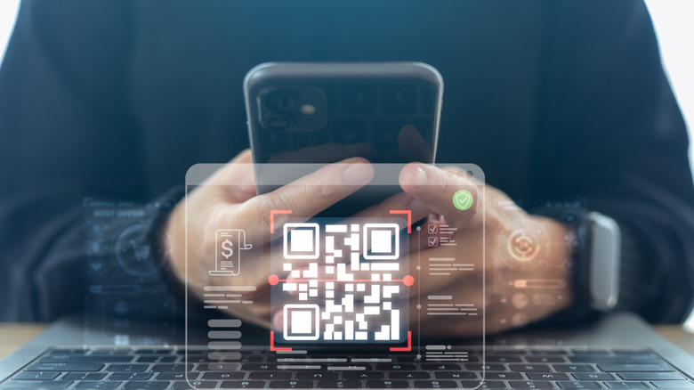 Someone holding their smartphone with a QR code overlaid below.