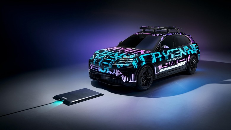 The 2026 Porsche Cayenne Electric driving over its charging base plate.