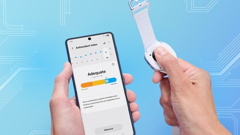 Hand holding Samsung phone showing Antioxidant Index page with the other hand's thumb on the back of Galaxy Watch