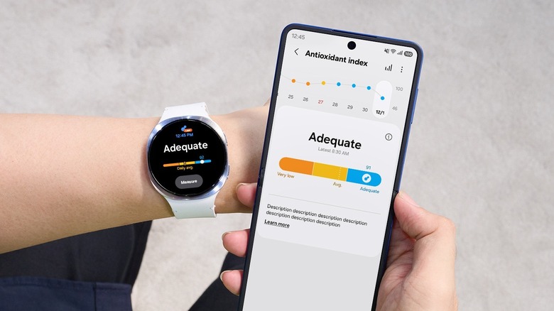 Hand holding phone while wearing Samsung Galaxy Watch showing Antioxidant index score