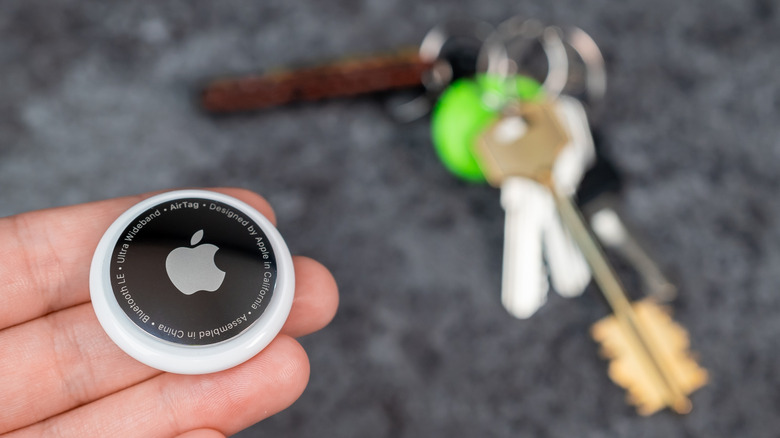 A series of Apple AirTags with holders and logos in a formation.