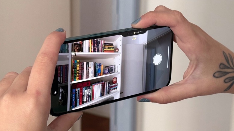A woman taking a photo using the iPhone 16's Camera Control