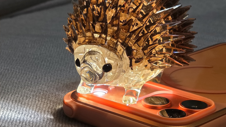 An iPhone 17 Pro flashlight lighting an ornament.