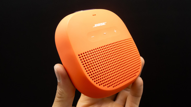 Hand holding a portable Bose speaker.