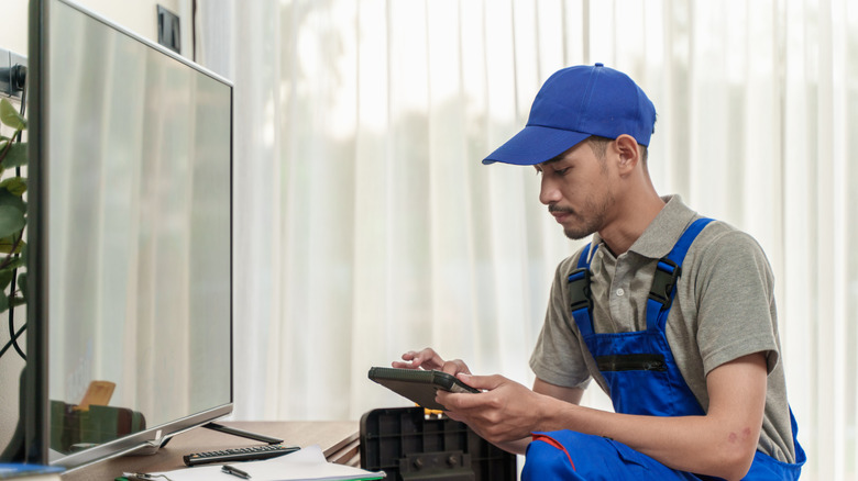 A TV repair tech setting up a new TV