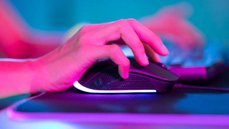 Person using gaming mouse on top of desk.