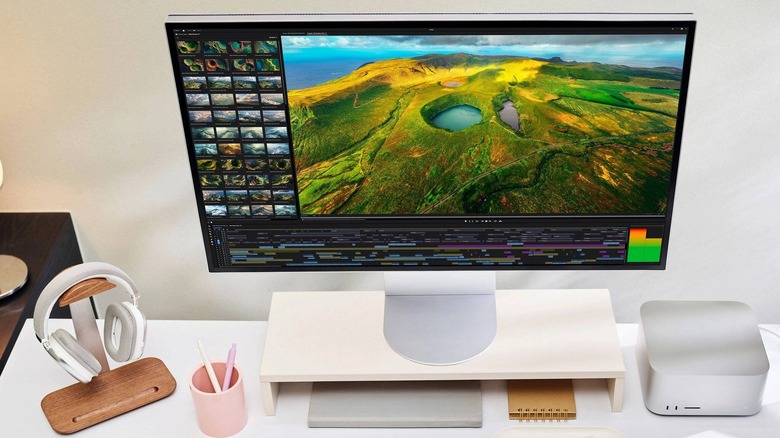 The LG UltraFine evo 6K monitor on a monitor stand as a part of a desk setup with peripherals