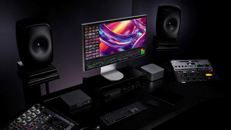 The LG UltraFine evo 6K monitor on a monitor stand as a part of a desk setup with audio gear