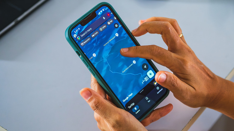 Two hands navigating a saved map on the Google Maps app