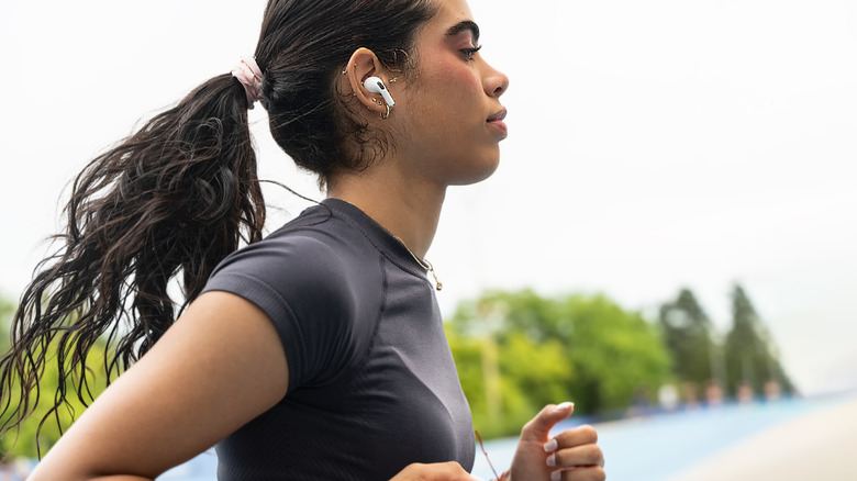 A person listening to music with their AirPods while working out.