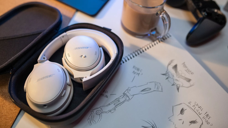 Bose QuietComfort 45 headphones sitting on a desk in a case