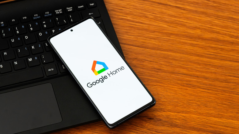 the Google Home app open on a smart phone that is sitting atop a keyboard