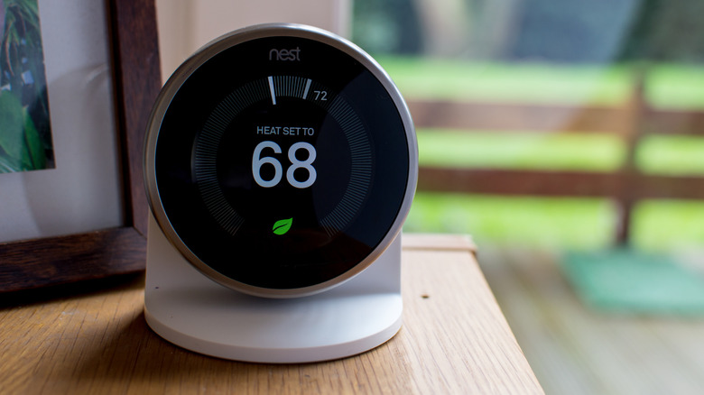 a Google Nest Thermostat sitting on a table in a room with the heat set to 68