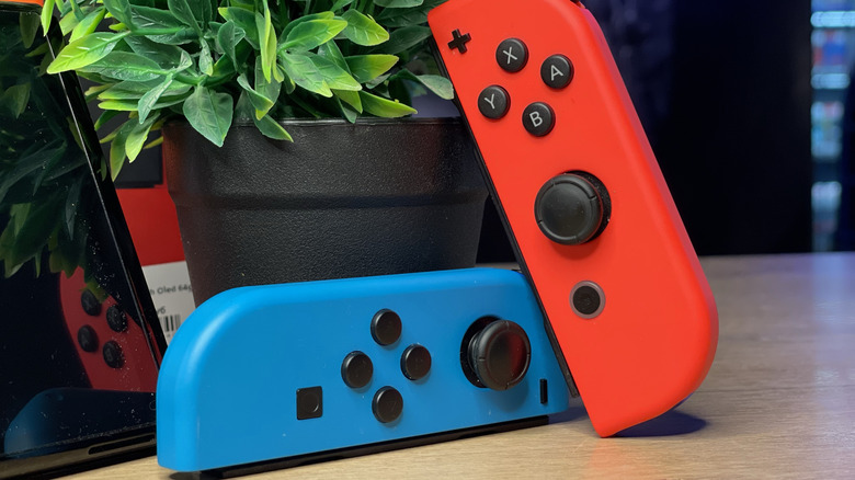 Close up of the Nintendo Switch Joy-Cons in neon blue and red next to the console.