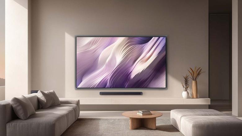 Samsung S95H OLED TV mounted on a living room wall above a soundbar.