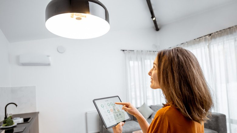 A homeowner controlling smart lighting with a tablet