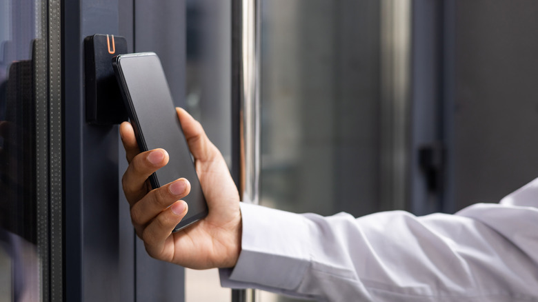 Person with a smartphone opening a smart lock.