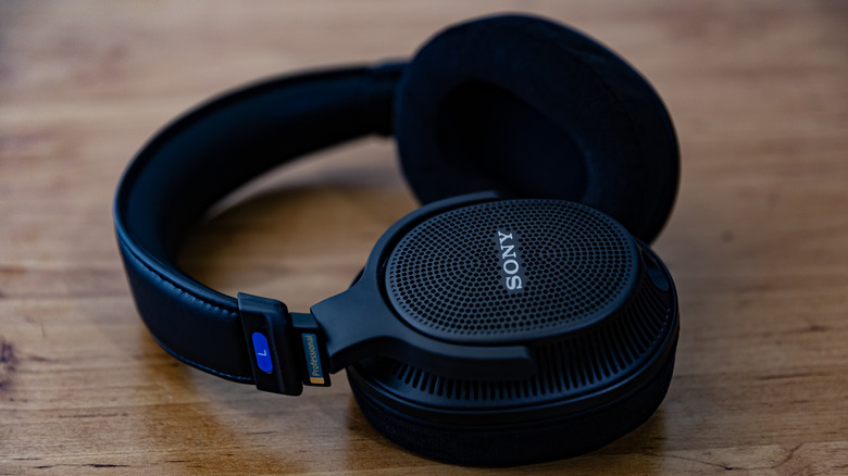Professional Sony open-back headphones resting on a wooden tabletop.