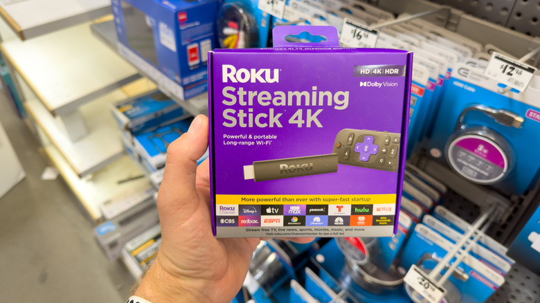 Roku Streaming Stick 4K box and packaging in hands at the store.