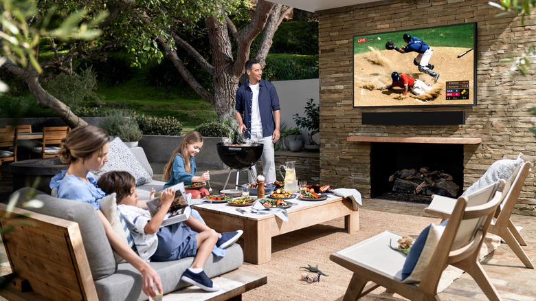 A family outside watching the baseball game on a Samsung The Terrace outdoor TV.