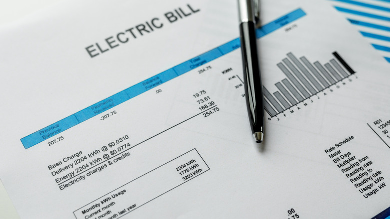 An electric bill and pen on a table.