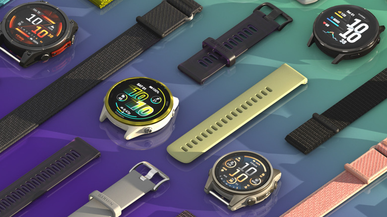 Several Garmin smartwatches on a green and purple background