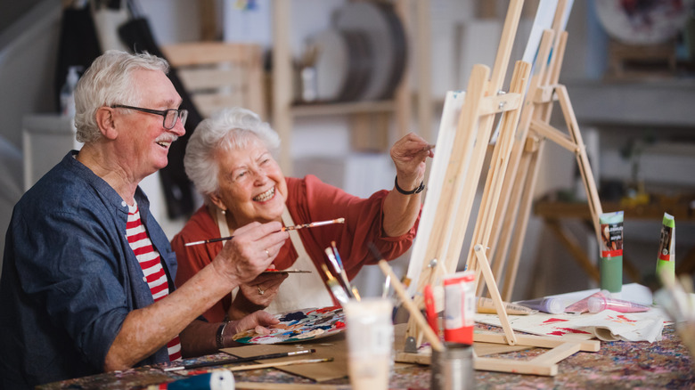 an elderly couple having fun painting