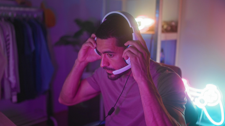 Young man putting on a gaming style headset.