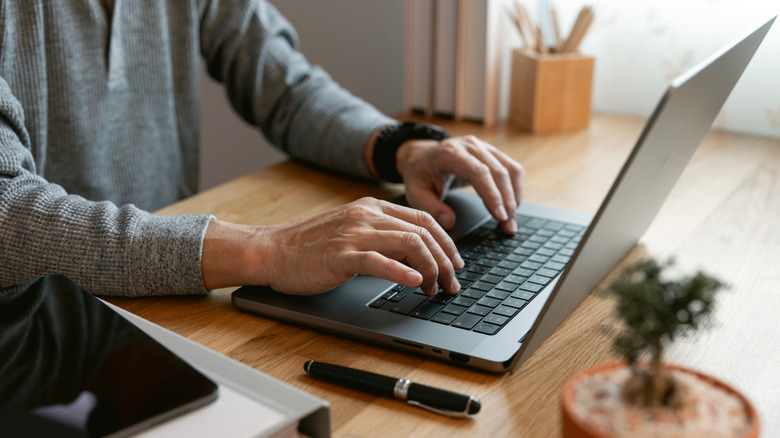 person typing on laptop at home