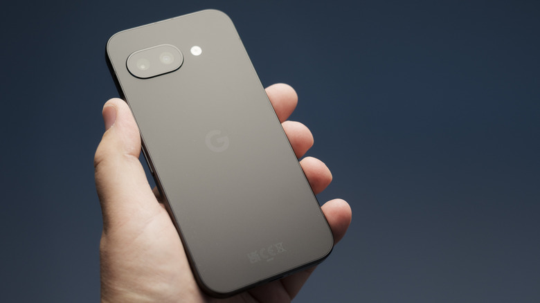 Hand holding a Google Pixel 9a smartphone.