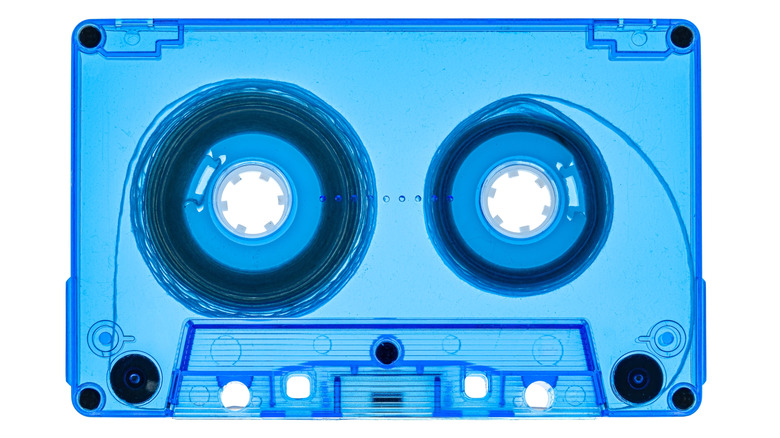 A cassette tape with the reel-to-reel tape visible inside the housing.