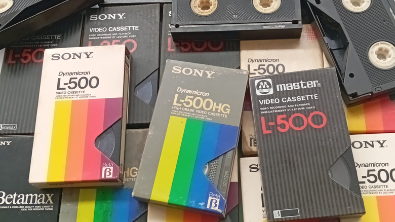 VHS tapes of varying types stacked in a pile.
