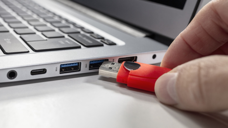 A USB stick being plugged into a laptop
