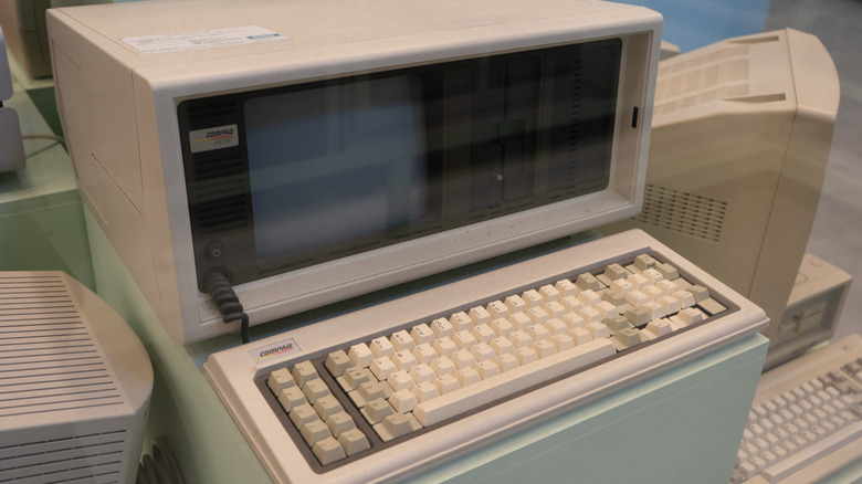 An old Compaq computer surrounded by other older computers