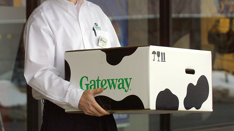 An employee carries a Gateway computer box