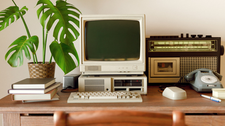 An old computer on a desk with other retro gear