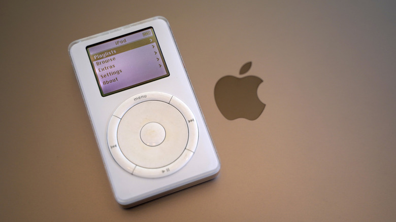 The original iPod on top of a MacBook laptop.