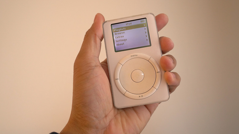 A person holding the original iPod in hand.