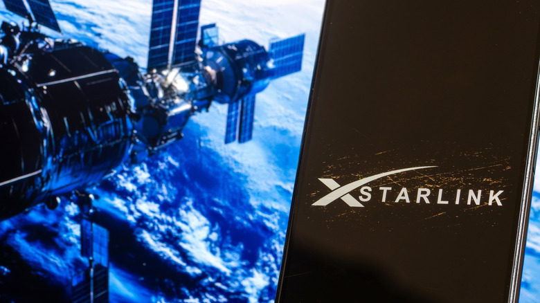 Starlink logo on antenna with satellite in orbit in the background.